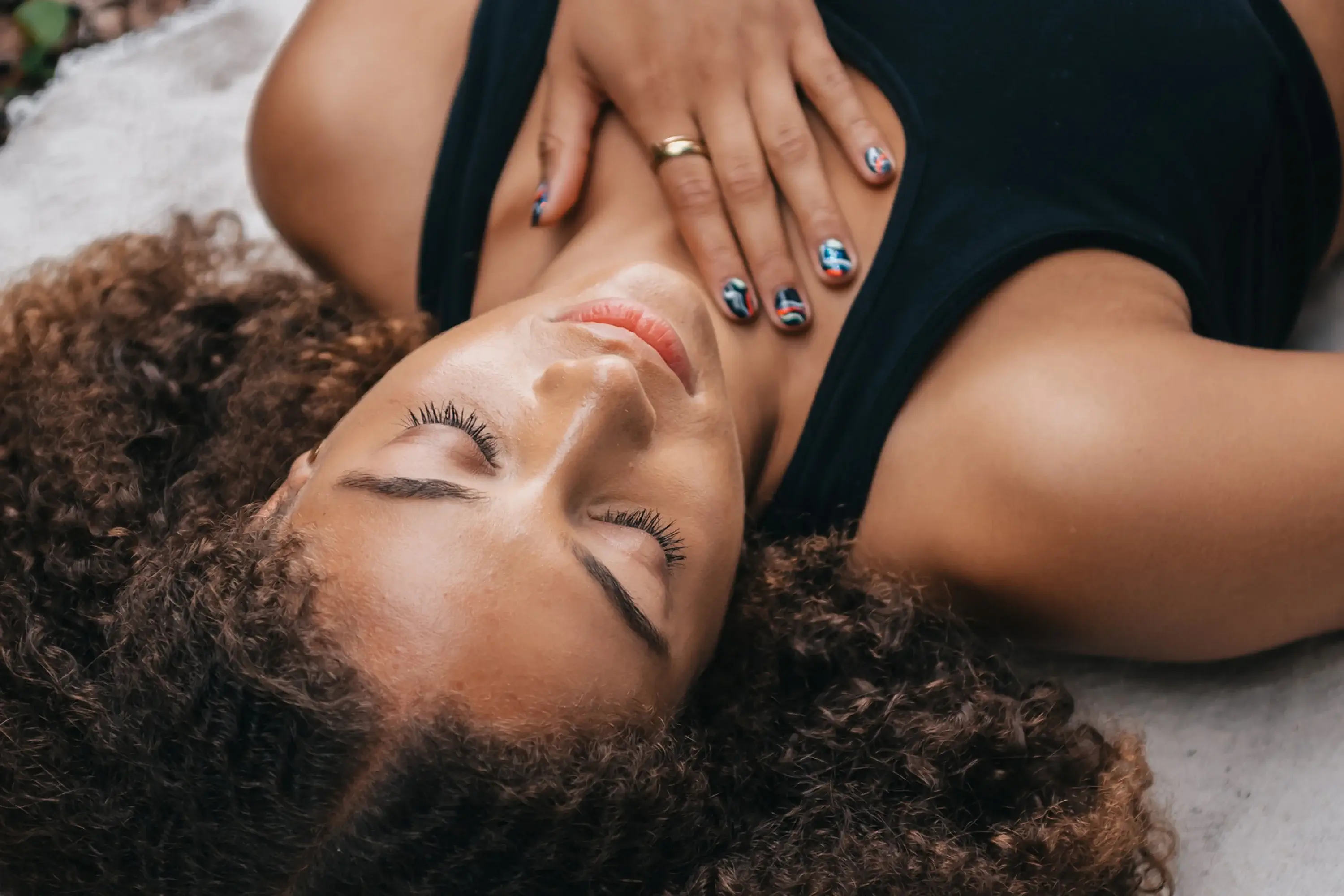 woman lying down with eyes closed and hand on heart